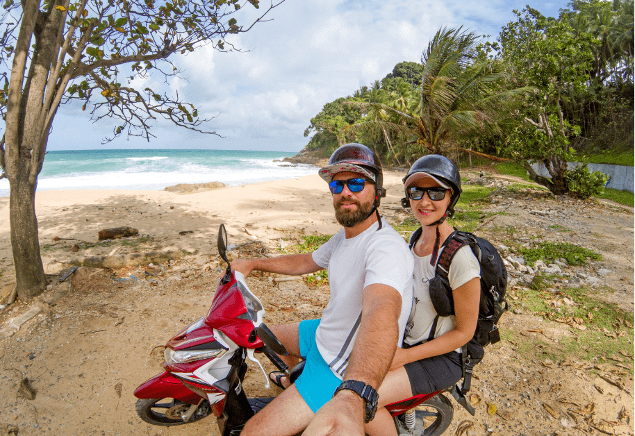 couple riding a motorbike near the beach